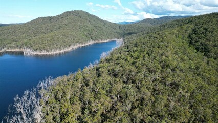 Scenic aerial view of a tranquil lake surrounded by lush green hills, creating a tranquil atmosphere
