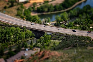 Cars driving on a bridge spanning a busy city street