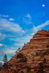 Fototapeta na wymiar Areal view of the moon in the sky over a mountain in Zion National Park in Utah