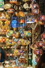 Ornate and vibrant collection of Turkish lamps hangs from the window of an authentic market