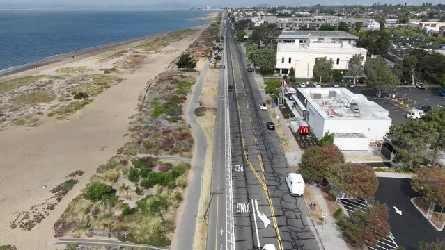 Hyperlapse drone footage of cars driving on the coastal road adjacting to Crown Beach in Alameda, CA