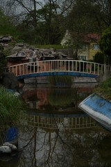 Fototapeta na wymiar a bridge crossing the stream through a lush green park area