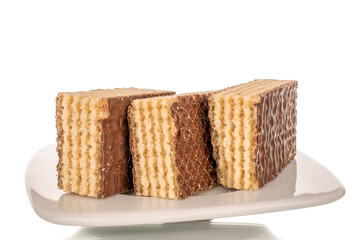 Three sweet chocolate wafers on a white ceramic saucer, macro, isolated on a white background.