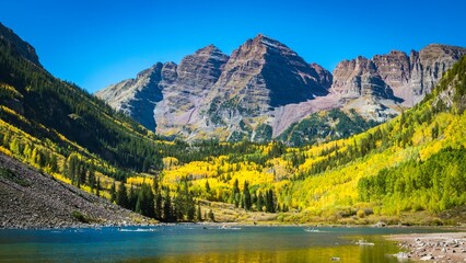 Fototapeta premium Tranquil lake surrounded by majestic mountains under a bright sky, with trees in the foreground