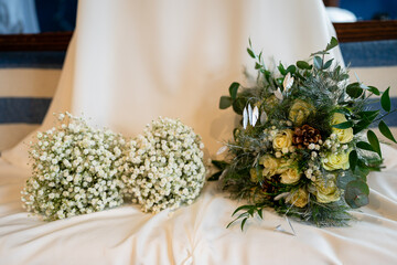 Chic White and Green Foliage Bridal and Bridesmaid Bouquets on a white wedding dress.