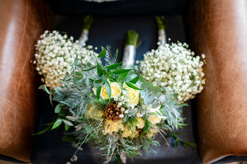 Chic White and Green Foliage Bridal and Bridesmaid Bouquets on a Leather Couch