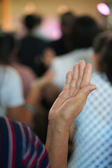 Human raising hand worshiper at Church.