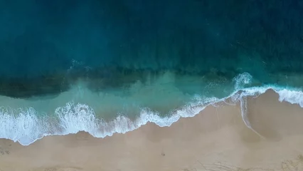 Foto op Plexiglas Aerial view of sea waves crashing against a beach in the daylight © Wirestock