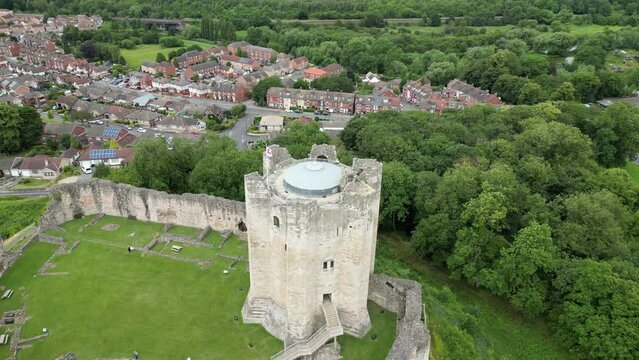 Drone view of the Conisbrough Castle surrounded by green vegetation in Conisbrough, England