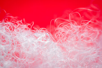 Extreme macro of polyester stable fiber on red background