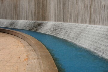 Picturesque scene of a large fountain situated in front of a grand cascading wall of water.