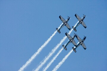 a formation of four airplanes flying through the sky at a military ceremony