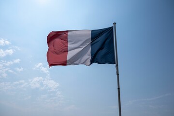 French tricolor flag proudly displayed against a blue sky