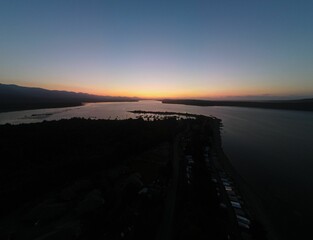 the sunset reflects off of a lake with mountains in the distance