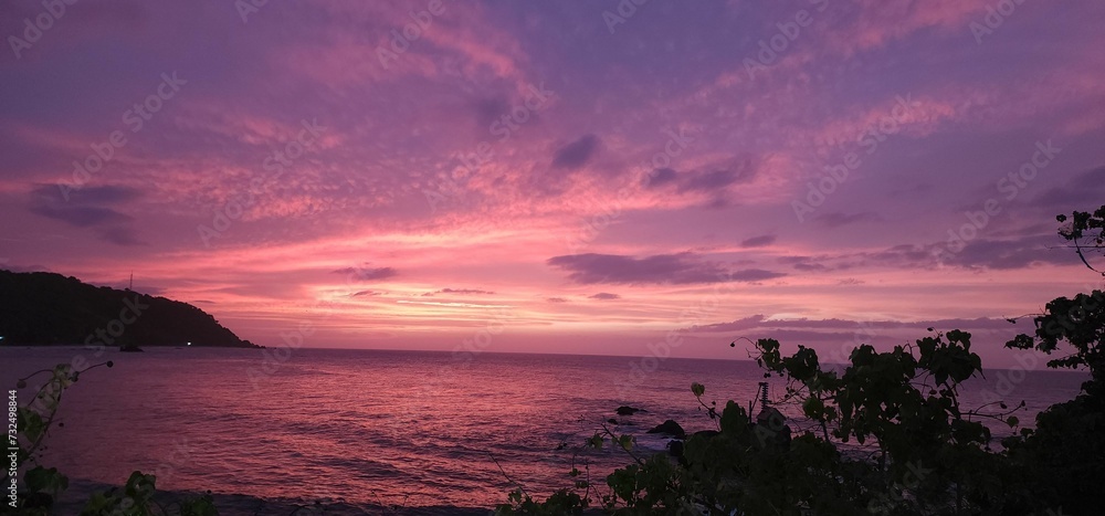 Sticker Panoramic view of the beach against a sea at purple sunset