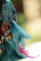 Close up shot of an ornamental Indian dream catcher hanging on blurred background outdoors