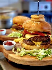 Closeup shot of a freshly prepared hamburger served on a rustic wooden cutting board.
