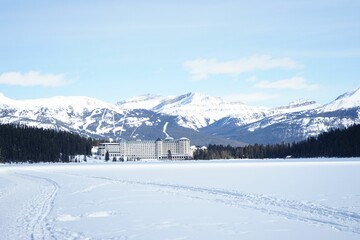 Fototapeta na wymiar Large resort in a winter landscape covered in white snow and majestic mountains peaks in backdrop