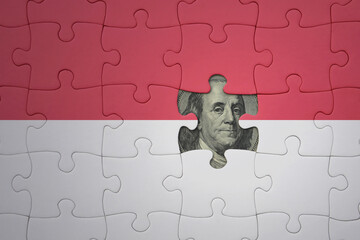 puzzle with the national flag of indonesia and usa dollar banknote. finance concept