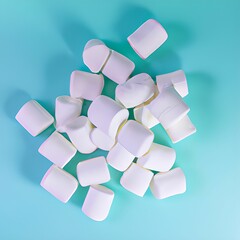 Overhead view of white marshmallows against a light blue background