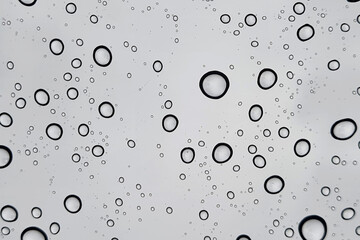 Rain drops on window glasses surface with cloudy background . Natural Pattern of raindrops isolated...