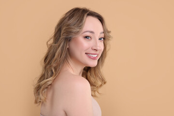 Portrait of smiling woman on beige background