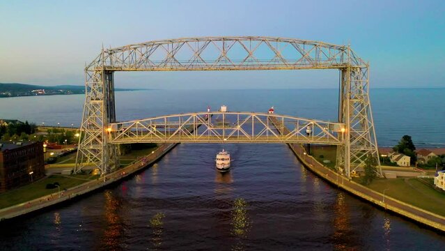 Ship passing under the Aerial Lift Bridge in Duluth, Minnesota at sunset