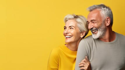 beautiful smiling bright couple 60 years old in comfortable clothes on a yellow background. The concept of a happy and prosperous life in retirement. Copy space