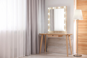 Beautiful mirror with light bulbs and lamp in makeup room