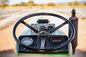 a tractor steering with gauges on the seat in a field