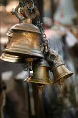 Closeup shot of a cluster of antique-style bells hangs.