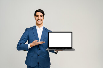 Man in a smart blue suit stands against a clean background, holding a laptop with a blank screen towards the camera, the perfect template for graphic designers to superimpose an application or website - obrazy, fototapety, plakaty
