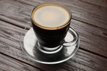 Cup of aromatic coffee on wooden table, closeup