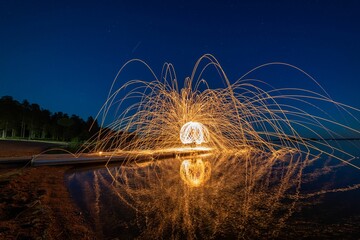 Night scene featuring a burning fire created by spinning steel wool with a long exposure.