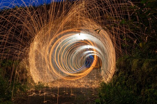 Night scene featuring a burning fire created by spinning steel wool with a long exposure.