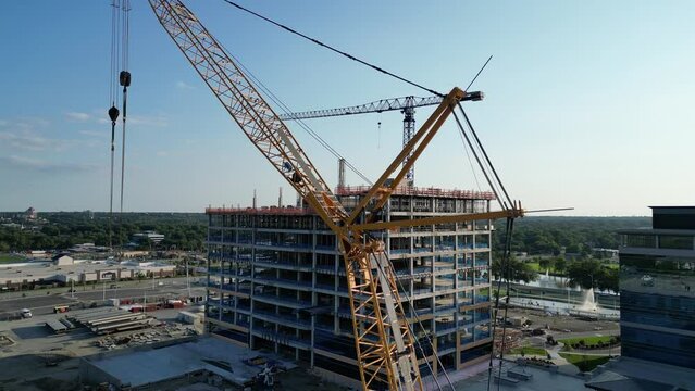 Drone shot of a Crane in construction site with under construction building in the background