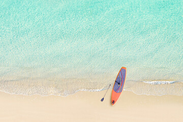 Top view of SUP board for surfing on the shore on tropical Seychelles sand beach. Blue, turquoise...