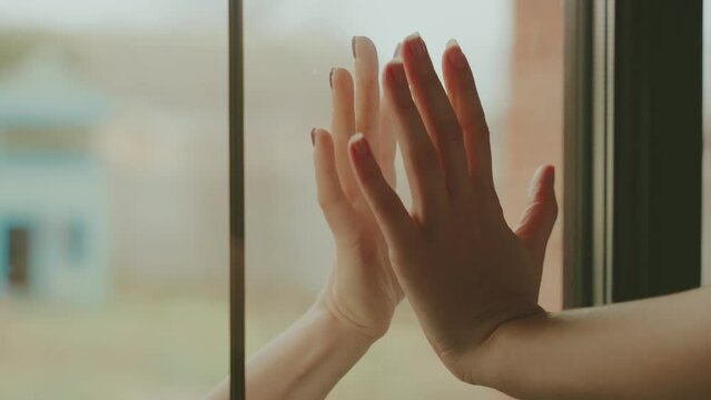 shot close-up human hand in outdoor visits sick friend in self-isolation quarantine safe communication, two people put their hands together through glass window. stay at home. arm person without face