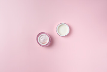 Jar of cream isolated on pink background, top view