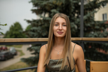 Portrait of a young beautiful blonde girl in a city summer park.