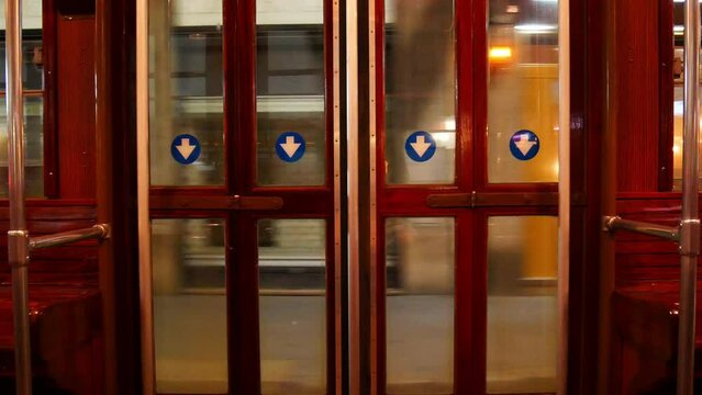 Internal automatic exit door of the moving tram in Milan, Italy by night
