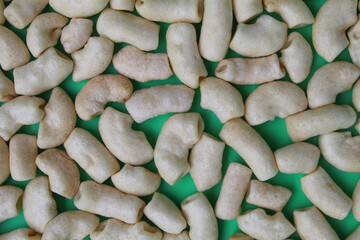 Fried macaroni crackers, on green background