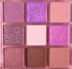 Eyeshadow palette with shimmer and matte warm colors. Nine bright and neutral colors in squares. Full frame. Make-up background