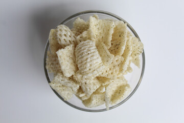 Crackers in net shape, in transparent glass bowl. isolated on white background, flat lay or top view