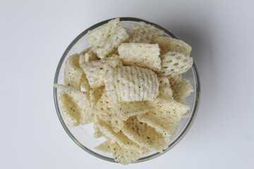 Crackers in net shape, in transparent glass bowl. isolated on white background, flat lay or top view