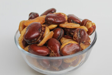 Kacang koro, or cooked jack bean, in a transparent glass bowl, isolated on white background