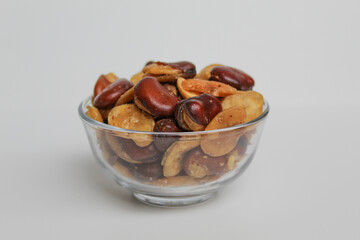 Kacang koro, or cooked jack bean, in a transparent glass bowl, isolated on white background