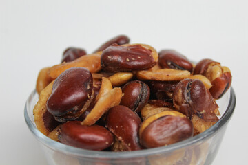 Kacang koro, or cooked jack bean, in a transparent glass bowl, isolated on white background