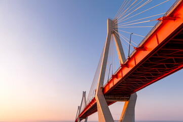Cable-stayed bridge in the light of the morning sun and against the background of a clear blue sky. Moore. Russia.