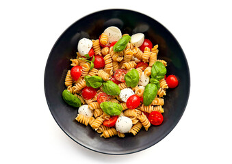 Organic Italian Chickpea Fusilli Pasta alla Caprese. Gluten-Free, Grain-Free, and Vegan Pasta Salad. Healthy Eating Concept. Top View, Isolated on White Background
